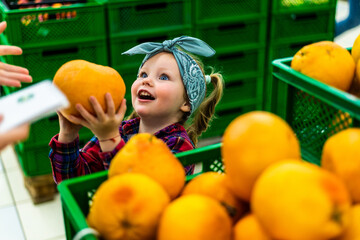 Family customers, mom and daughter buying ripe fruits in supermarket
