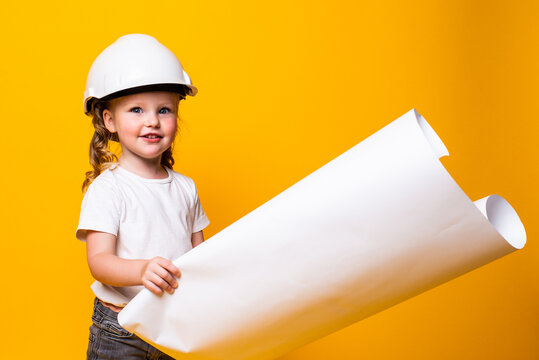 Cute little girl engineer with helmet holding bluepring on yellow background