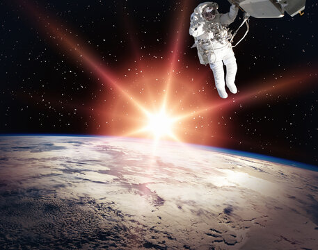 Astronaut and beautiful sunrise. The elements of this image furnished by NASA.
