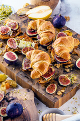 view of delicious freshly baked croissants with figs, pears, nuts and honey