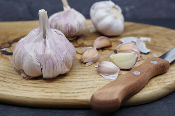 Organic garlic. Fresh garlic cloves and garlic bulb on a wooden cutting board. Garlic for healthy eating. Concept of spices for healthy cooking. Closeup