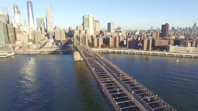 Revelando el skyline de Manhattan, Nueva York, con una vista a&eacute;rea sobre el puente de Brooklyn con autos circulando.