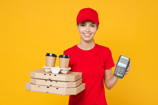 Delivery employee woman in red cap blank t-shirt uniform work courier service hold payment terminal give food order pizza in cardboard flatbox, paper cups of coffee tea isolated on yellow background.