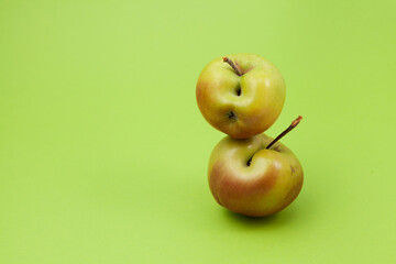 Ugly fruit. Two green apples with flaws on a light green background with copy space. Selective focus. Concept - Food waste reduction. Using in cooking imperfect products