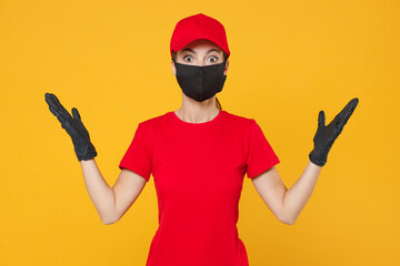 Delivery employee woman in red cap blank t-shirt uniform protect face mask gloves working courier in service during quarantine coronavirus covid-19 virus isolated on yellow background studio portrait.