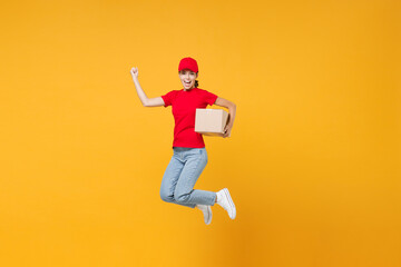Fototapeta na wymiar Full length body jumping delivery employee woman in red cap blank t-shirt uniform work courier in service during quarantine coronavirus covid-19 virus hold cardboard box isolated on yellow background.