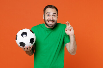 Man football fan in green t-shirt cheer up support favorite team with soccer ball wait for special...