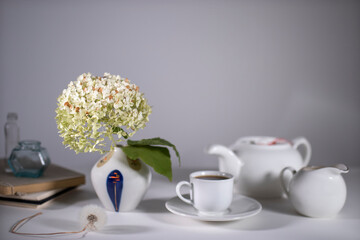 White teapot, cup and saucer and milk jug for tea drinking.