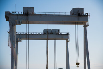 Harbor gantry crane moving a tank container