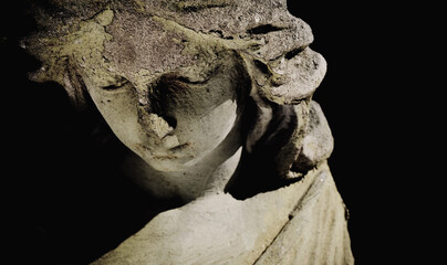 Death. Close up beautiful and sad angel as symbol of pain, fear and end of life. Fragment of ancient stone statue.