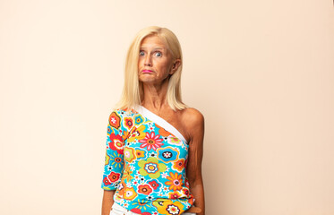 middle age woman feeling sad and stressed, upset because of a bad surprise, with a negative,...