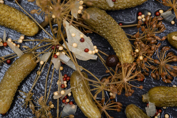 Extra Fine Cornichons - minuscule sour French pickles on natural stone background. Mini French style Gherkin Cucumbers.