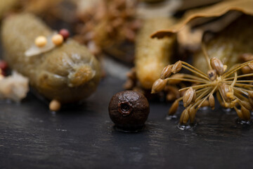 Extra Fine Cornichons - minuscule sour French pickles on natural stone background. Mini French style Gherkin Cucumbers.