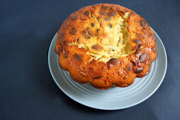 round pumpkin seed pie made from corn and rice flour on a gray plate on a black background side view . gluten-free baked goods made at home