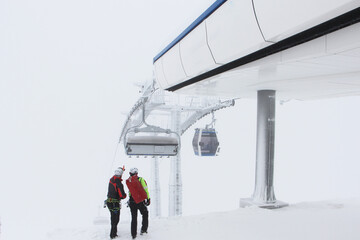 Heroes rescue teams on a chairlift at ski resort on the Dolomites. Emergency rescue passengers with...
