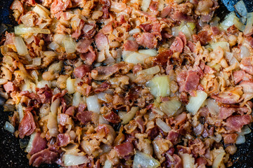 Fried bacon with onions in the frying pan