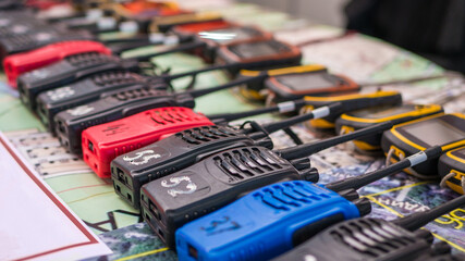 Portable emergency walkie talkie and navigators in a row at emergency services show. Equipment of...