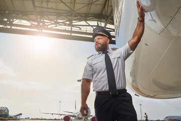 Professional pilot near his plane in the airport