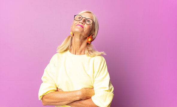 Middle Age Woman Feeling Happy, Proud And Hopeful, Wondering Or Thinking, Looking Up To Copy Space With Crossed Arms