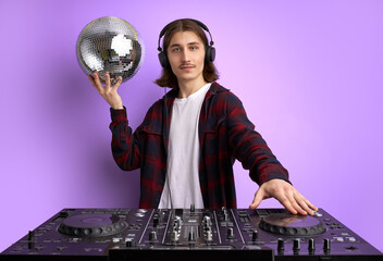 cool young DJ at work, spinning on turntable, mixing console. disco, club, music concept