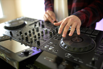 Obraz premium cropped dj mixes the track, perform music with the use of equipment.DJ equipment, headphones, microphones, vinyl. before the party, studio shoot