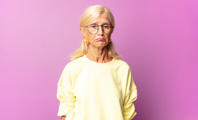 middle age woman feeling sad and stressed, upset because of a bad surprise, with a negative,...