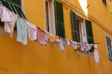 Fototapeta na wymiar Typical glimpse of the Ligurian alleys: cloths lying outside the balconies