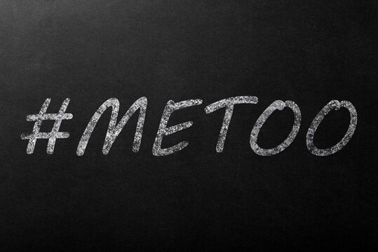 The inscription "#metoo" in white chalk on a dark blackboard.