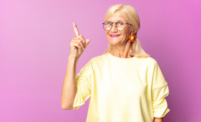 middle age woman feeling like a happy and excited genius after realizing an idea, cheerfully...
