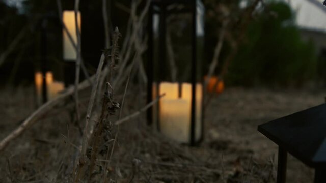 Slow motion shot of a witchy lantern on a dry dirt trail at dusk. Shot with a low depth of field that begins out of focus
