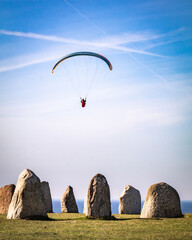 Paragliding at Ales stenar in Abbekås, Sweden. - obrazy, fototapety, plakaty