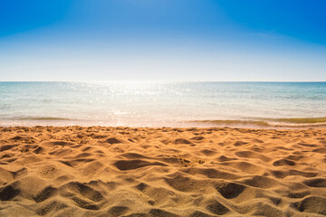 Fototapeta na wymiar Yellow sand beach near sea water. Blue clear sky.