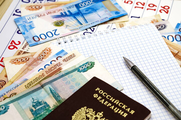 Russian passport on paper money. Notepad and pen on Russian banknotes.