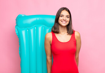 young pretty woman looking proud, confident, cool, cheeky and arrogant, smiling, feeling successful