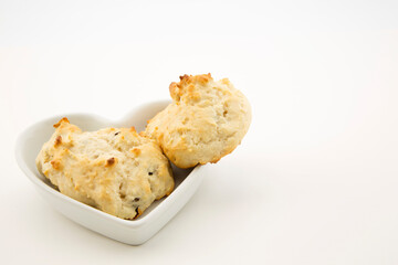 Drop biscuits are comfort food in heart shaped dish with white background