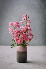 Floral background. Wild roses in a glass jar over stone background. Still Life Flowers. Nature.