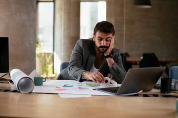 Young businessman working on projects. Tired businessman in suit working in the office.