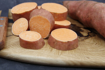 Sweet Potatoes on a wooden cutting board. Organic sweet potato for healthy eating. Closeup