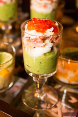 Verrine with avocado cream, shrimp, salmon eggs in a vintage sculpted glass.