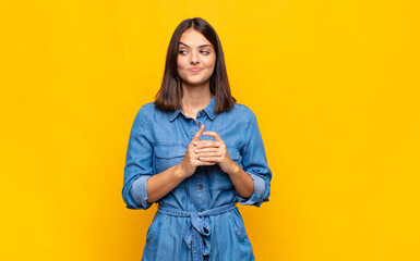 young pretty woman feeling proud, mischievous and arrogant while scheming an evil plan or thinking...