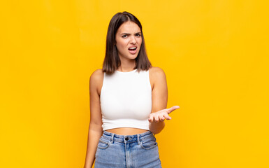 young pretty woman looking angry, annoyed and frustrated screaming wtf or what‚Äôs wrong with...