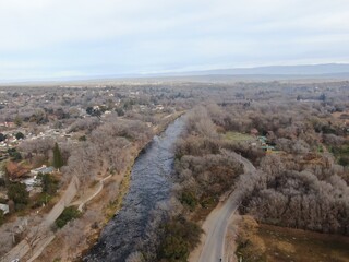 Vista a&eacute;rea de un r&iacute;o de monta&ntilde;a que atraviesa un valle, con rocas en el fondo del r&iacute;o, rodeado de &aacute;rboles, casas de verano y monta&ntilde;as al fondo. C&oacute;rdoba, Argentina.