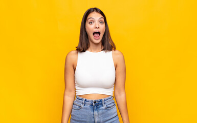 young pretty woman feeling terrified and shocked, with mouth wide open in surprise
