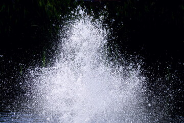Close up of water splashing from a fountain on a black background