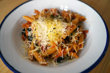 Penne pasta with tomato sauce, parmesan cheese and fresh basil