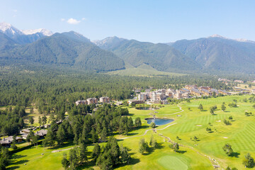 Aerial view from a drone. Stunning mountain views, hotels in the ski resort of Bansko, green golf courses in the morning at dawn. Travel and vacation concept