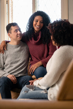 Happy Brazilian Interracial Couple With Mother In Law Spending Time Together Inside The House In Living Room. Affectionate, Bonding, Love, Generation Concept..