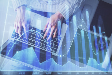 Multi exposure of woman hands working on computer and forex chart hologram drawing. Top View. Financial analysis concept.