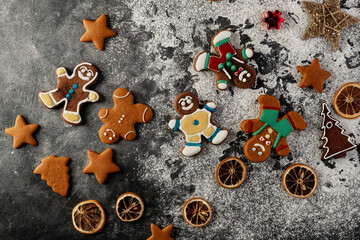 Obraz na płótnie Canvas Various christmas gingerbread cookies on dark table with flour