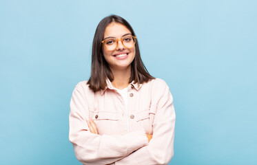 young pretty woman looking like a happy, proud and satisfied achiever smiling with arms crossed